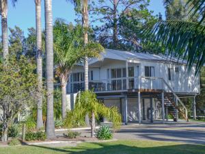 阳光湾凯西斯海滩假日公园酒店的前面有棕榈树的房子