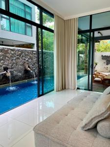 珍南海滩Ikiru 18 Private Saltwater Pool Villa, 3 Ensuite BR, Outdoor BBQ, 5 mins to Beach的一间卧室设有一张床和一个游泳池