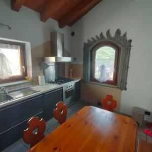 费尼斯La Maison Lillà的厨房配有木桌、水槽和炉灶。