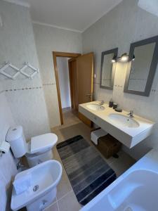阿尔沃尔Apartamentos Santa Teresinha的浴室设有2个水槽、卫生间和镜子。