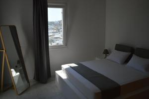 米克诺斯城Revel Mykonos 4的一间卧室配有一张床、镜子和窗户