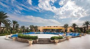 利雅德Dorat Najd Resort的一个带游泳池和棕榈树的度假村
