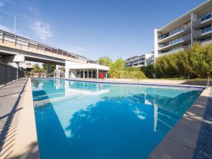 布里斯班Oaks Brisbane Mews Suites的大楼前的大型游泳池