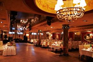 哈尔科夫Misteriya Hotel的一间配备有白色桌椅和吊灯的餐厅