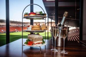 布莱克浦Blackpool Football Club Stadium Hotel, a member of Radisson Individuals的一张桌子,上面放着两盘食物和两杯葡萄酒