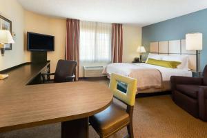 威奇托MainStay Suites - Wichita NE的酒店客房配有一张床铺和一张桌子。