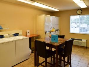 威奇托MainStay Suites - Wichita NE的厨房配有桌椅和柜台。