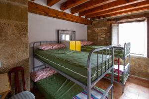 滨河托雷斯Hostal Rural La Pata de Oca y albergue solo por peregrinos的带窗户的客房内的两张双层床