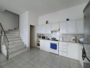 ParánimfoiCozy Beach House South Crete的一间厨房,配有白色橱柜和楼梯