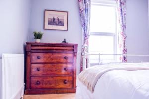 切尔滕纳姆Lovely 3 bed house in the heart of Cheltenham的一间卧室配有木制梳妆台和一张床