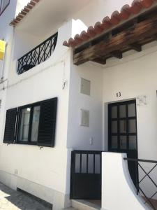 奥德赛克斯Casa dos Pais的白色的房子,有黑色的门和窗户