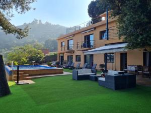 布拉内斯VILLA LA CALA with swimming pool & sea view, 10 min walk from the sea的一个带椅子的庭院和游泳池的房子