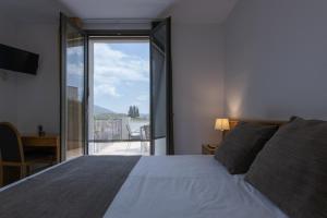 托尔特利亚阿尔塔格罗塔萨旅馆的一间卧室设有一张床,享有阳台的景色