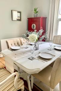 切尔滕纳姆Stunning 3 bed house in the heart of Cheltenham的餐桌上摆放着盘子和鲜花