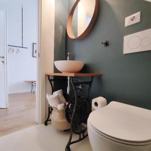 博洛尼亚Casa Tulù B&B的一间带水槽、卫生间和镜子的浴室
