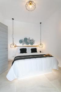 米科利维亚Villa Oceana的白色卧室配有一张带两个灯的白色大床