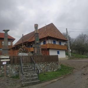 BartoştanaSzékelyföld ,Siklódi Kő Vendégház, Tornácosház的一座大型木屋,前面设有围栏