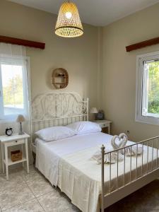 干尼亚Orange Country House的卧室配有白色的床和吊灯。