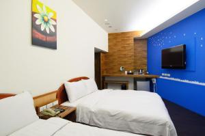 马公玉堂饭店精品旅馆的一间酒店客房,设有两张床和电视