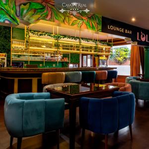 里奥班巴Spa皇家金堡酒店的一间设有蓝色椅子的餐厅和一间酒吧