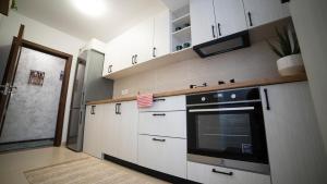 雅西Ballade Apartment的厨房配有白色橱柜和黑烤箱。