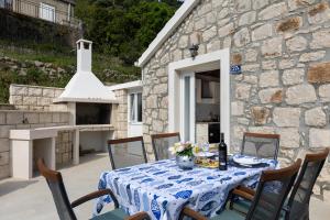 ProžuraPERLA - small comfy house with the terrace的露台上一张桌子,上面有蓝白的桌布