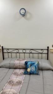 卡塞塔B&B LA REGGIA DI RIHANNA spa的一张带两个枕头的床和墙上的时钟