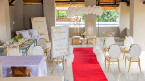 焦济尼Siyaya’s Guest Palace的一个带桌椅和红地毯的宴会厅