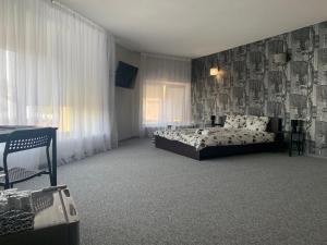 马里扬泊列Hotel Marijampole的一间卧室配有一张床、一张桌子和一个窗户。