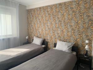 马里扬泊列Hotel Marijampole的客房设有两张床和壁纸墙