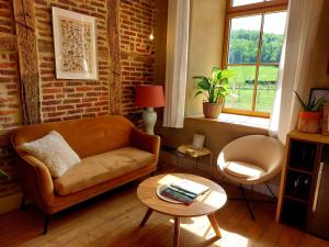 杜柏Les Suites de Petit Bomal的客厅配有沙发和桌子