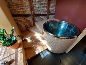 杜柏Les Suites de Petit Bomal的一个大浴缸,位于房间角落