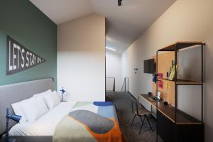 马德里The Social Hub Madrid的一间卧室配有一张床和一张书桌及电视