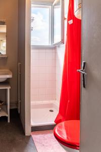 塔布Le Debussy - studio - WIFI FIBRE- centre ville- parking的带淋浴和红色卫生间的浴室