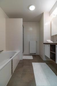 奥斯坦德Laluna holiday apartment的白色的浴室设有浴缸和水槽。