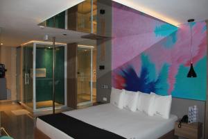 ItaquaquecetubaSky Motel Itaqua的一间卧室配有一张带彩色墙壁的床
