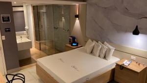 ItaquaquecetubaSky Motel Itaqua的卧室配有一张白色大床和淋浴
