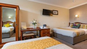 都柏林埃甘斯酒店的酒店客房配有两张床和一张书桌