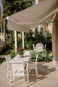 尼基季casale的白色遮阳伞下的白色桌子和椅子