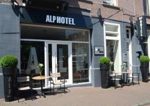 阿姆斯特丹阿尔卑斯山酒店的大楼前的商店,有桌椅
