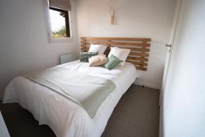 莫列马阿Chaleureux appartement à 500m de l’océan et 150m du Golf Moliets-Plage的卧室配有一张带白色床单和枕头的大床。