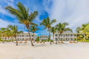 圣佩德罗Tara Del Sol Resort的海滩上一座种植了棕榈树的大型白色建筑