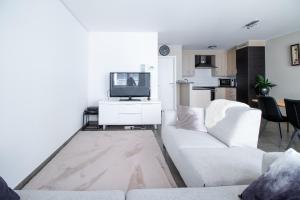 奥斯坦德Laluna holiday apartment的客厅配有白色沙发和电视