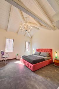 穆拉诺Simone Cenedese Murano Apartments - Cristallo的一间大卧室,配有一张红色的床和吊灯