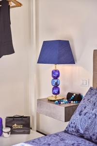 穆拉诺Simone Cenedese Murano Apartments - Cristallo的一张坐在床边桌子上的蓝色灯