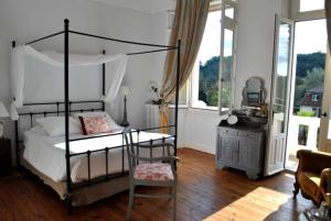 萨利耶德贝阿尔恩霍特比斯别墅的一间卧室配有一张天蓬床、椅子和一张桌子