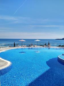 布德瓦ApartHotel Belvedere Residence Becici Budva的一个大型的游泳池,背景是大海