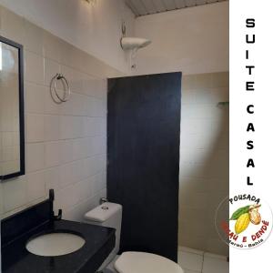 巴拉格兰德Pousada Cacau e Dendê的一间带卫生间、水槽和黑色门的浴室