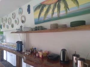 巴拉格兰德Pousada Cacau e Dendê的厨房配有木台,墙上挂有盘子