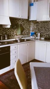 布伦托尼科Casa Criss的厨房配有白色橱柜、水槽和桌子